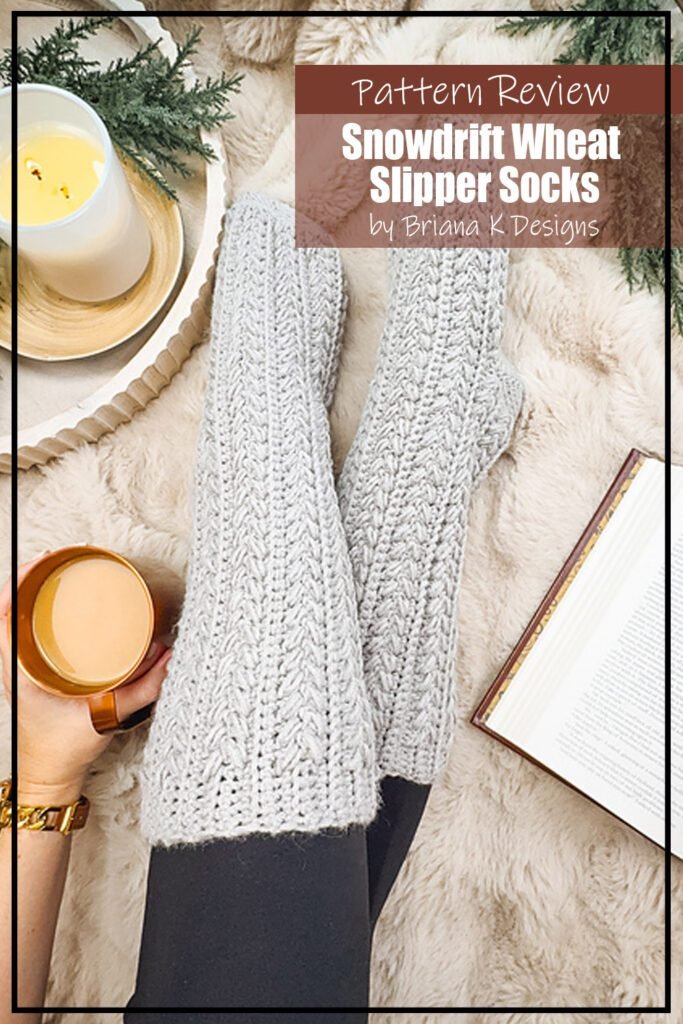 Snowdrift Wheat Slipper Socks crochet pattern sample is modeled by a person wearing black leggings with the grey coloured slipper socks over top. The text reads "Snowdrift Wheat Slipper Socks by Briana K Designs Pattern Review."