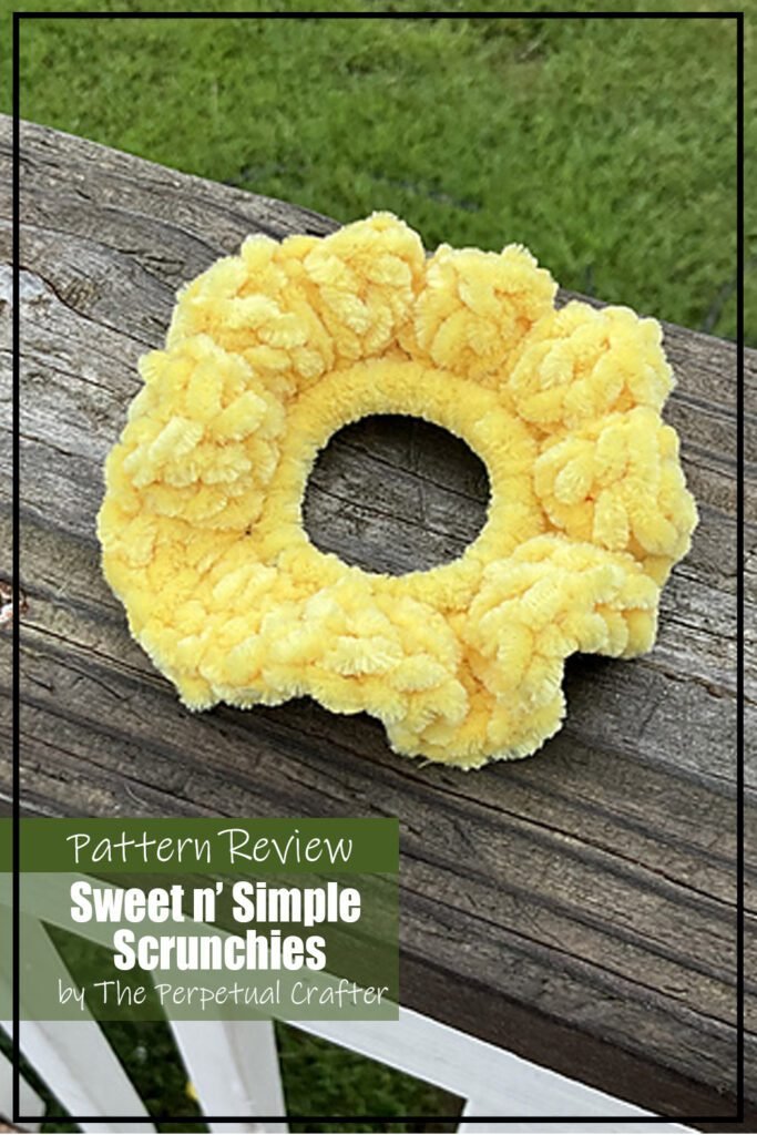 Sweet n Simple Scrunchies crochet pattern sample made with yellow yarn. The sample is displayed outdoors on a piece of wood. The text on the image reads "Sweet n Simple Scrunchies by The Perpetual Crafter Pattern Review".
