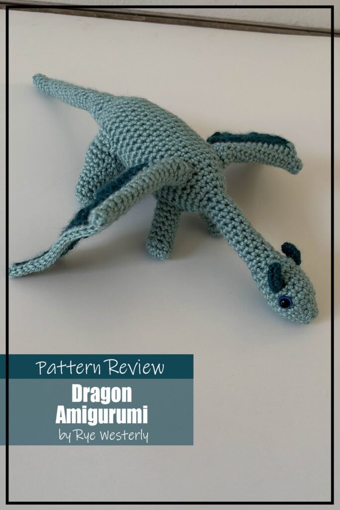 Dragon amigurumi crochet pattern sample is made with teal yarn and a darker teal/green for accents on the wings and horns of the dragon. Text on the image reads "Dragon Amigurumi by Rye Westerly Pattern Review".