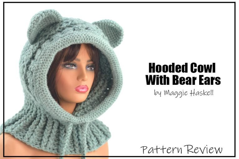 Hooded Cowl With Bear Ears crochet pattern sample is maded with a mint green yarn. The pattern is a mixture of hood and cowl. The crochet project is displayed on a plastic female mannequin head with a white background. The text on the image reads "Hooded Cowl With Bear Ears by Maggie Haskell Pattern Review".