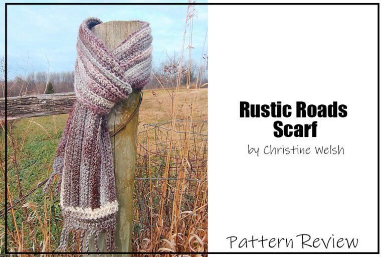 Rustic Roads Scarf crochet pattern sample is made with a burgundy and cream variegated yarn. The crochet scarf sample is hanging on a fence pole in a autumnal field. The text on the image reads "Rustic Roads Scarf by Christine Welsh Pattern Review."