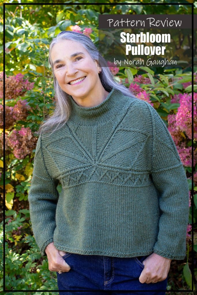 Starbloom knitting pattern sample is a beautiful green sweater pullover featuring a star motif made using twisted stitches and decreases. The sweater is modeled on a woman wearing jeans standing outside in front of a flowering bush. The text on the image reads "Starbloom Pullover by Norah Gaughan Pattern Review".