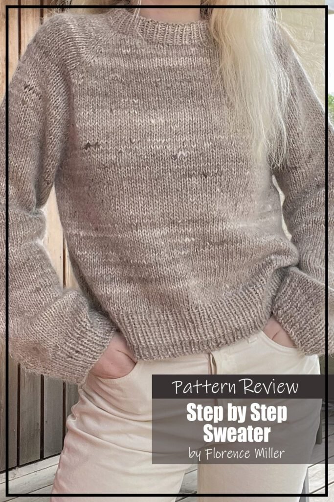 The Step by Step Sweater knitting pattern sample is knit using a beige aran weight wool. The sweater features ribbing at the collar, cuffs, and hem. The sweater is modeled on a woman with blond hair wearing light beige pants who is standing outside with her hands in her pockets. The text on the image reads "Step by Step Sweater by Florence Miller Pattern Review."