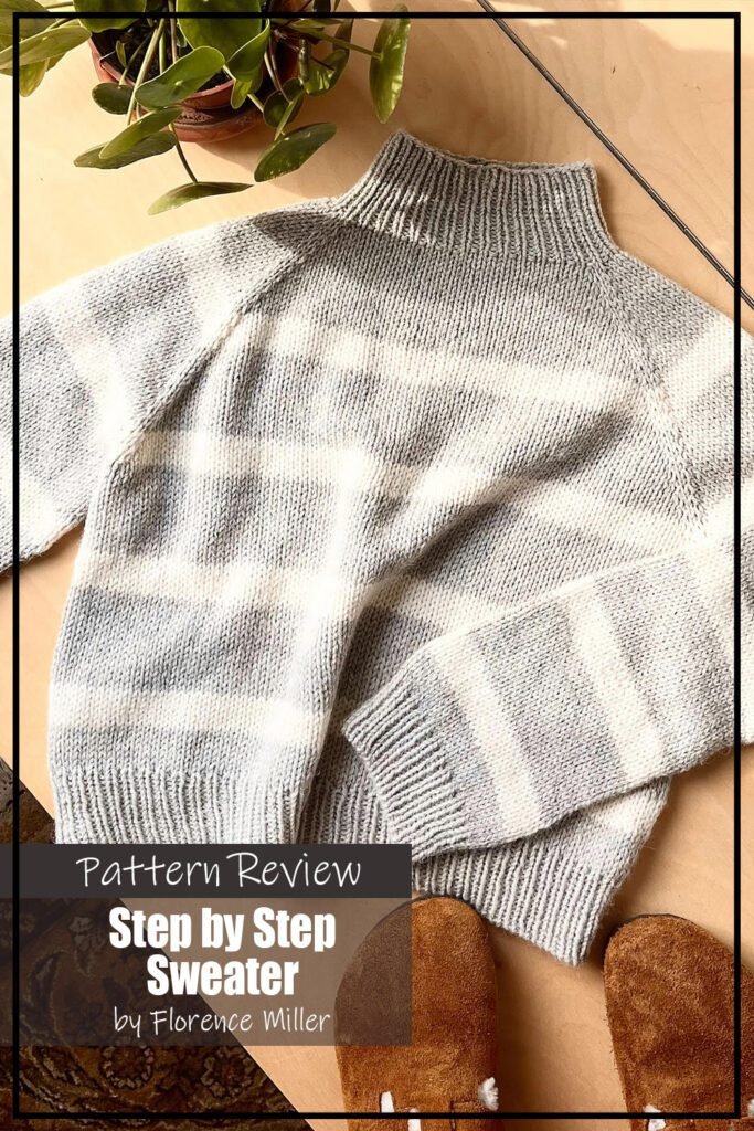 The Step by Step Sweater knitting pattern sample is knit using a beige aran weight wool. The sweater features ribbing at the collar, cuffs, and hem. The sweater sample is laid flat on a wooden surface. The text on the image reads "Step by Step Sweater by Florence Miller Pattern Review."