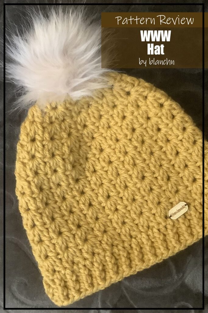 Crochet hat pattern sample made using yellow yarn and topped with a white pompom. Text on the image reads "WWW Hat by blanchn Pattern Review:".
