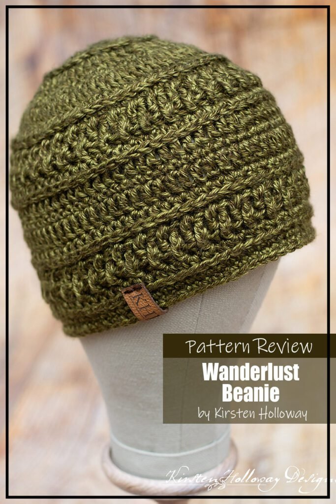 The Wanderlust Beanie crochet pattern sample is made using a tonal green worsted weight yarn with yellow understones. It is modeled on a mannequin. The text on the image reads "Wanderlust Beanie by Kirsten Holloway Pattern Review".