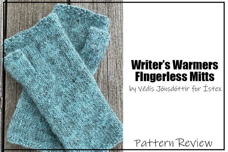 Writer's Warmers fingerless mitts by Védís Jónsdóttir for Ístex knit pattern sample shown laid flat on a wood background. The fingerless mitts are knit with a teal yarn with darker flecks running through it to give a nice dimension to the finished project. Text on the image reads "Writer's warmers fingerless mitts by Védís Jónsdóttir for Ístex Pattern Review".